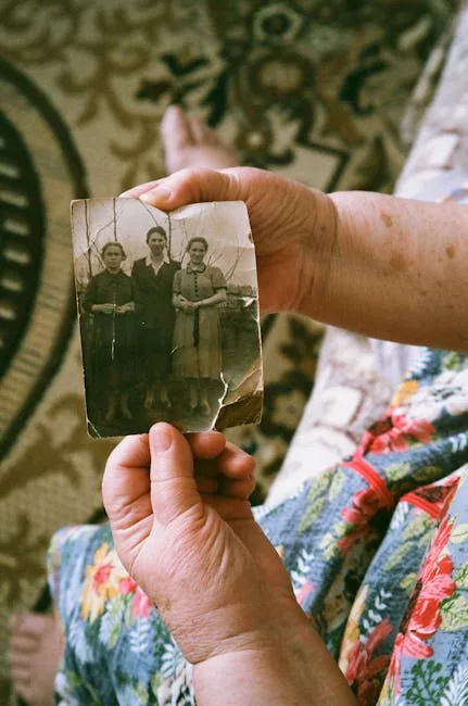 Крупный план рук со старой фотографией избегает идентификации живых людей и хорошо передает тему семейной памяти